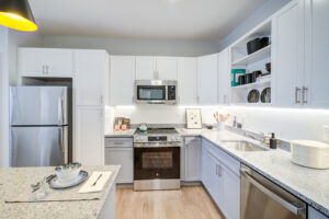 Spacious kitchen with white cabinetry and stainless steel appliances