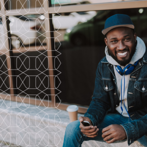 man sitting in city with a coffee, smiling